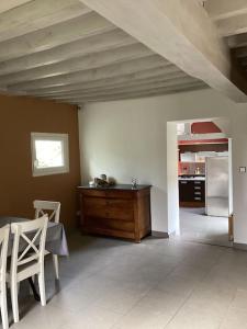 Zimmer mit einem Tisch und einer Küche mit einem Kühlschrank. in der Unterkunft LE GITE LACHELLE in Lachelle