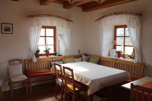ein Esszimmer mit einem Tisch, Stühlen und Fenstern in der Unterkunft Haus Schönegger in Kitzeck im Sausal