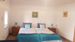 1 dormitorio con 2 camas y almohadas azules y blancas en Isabel de Gouveia en Belmonte