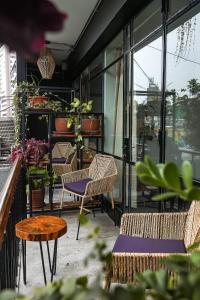 un patio con sillas, mesas y ventanas en Black Llama Hostel Miraflores en Lima