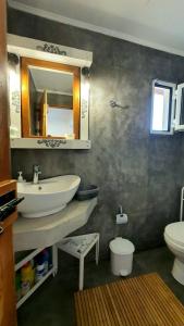 y baño con lavabo, aseo y espejo. en Konti villa, en Kondáraina