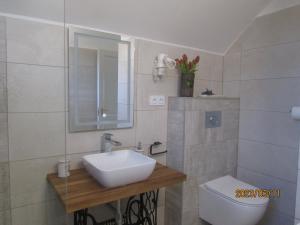 a white bathroom with a sink and a toilet at Levendulas Apartman in Balatonalmádi +21 photos