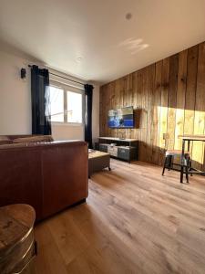 a living room with a couch and a television at Chez James in Gujan-Mestras