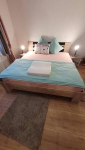 una camera da letto con un grande letto con lenzuola e cuscini blu di Omi's Nest, für klein und gross a Oberbüren