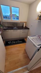 a small kitchen with a refrigerator and two windows at Omi's Nest, für klein und gross in Oberbüren