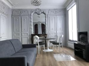 sala de estar con sofá, mesa y sillas en Maison Gabriel Appartement PLUME, en Abbeville
