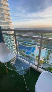 Un balcón con una silla y vistas al océano. en LeisureStay Studio @ Azure North en San Fernando