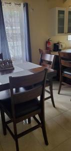 a table and chairs in a room with a kitchen at Hillside Retreat in Gated Community Close to Beach in Montego Bay