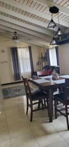 a dining room with a table and chairs and a couch at Hillside Retreat in Gated Community Close to Beach in Montego Bay