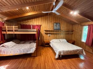 a bedroom with two bunk beds and a ceiling fan at Casa Alfalfal in San José de Maipo