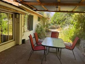 a patio with a table and chairs on a porch at Casa Alfalfal in San José de Maipo