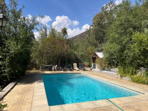 - une piscine dans une cour avec des arbres et une maison dans l'établissement Casa Alfalfal, à San José de Maipo