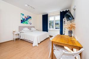 1 dormitorio con cama, mesa y escritorio en Apartament Gdynia, en Gdynia