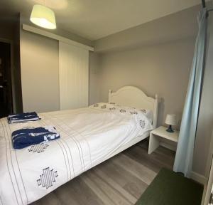 1 dormitorio con 1 cama con colcha blanca en Lovely 3 bed ground floor flat with free parking, en Swanage