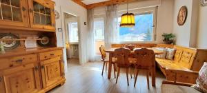 - une cuisine avec une table à manger et des chaises dans l'établissement DolomiApartments - Casa Daria, à Predazzo