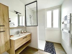 La salle de bains blanche est pourvue d'un lavabo et d'un miroir. dans l'établissement Caporizon-La Marote-Gite calme tout neuf, à Lanobre