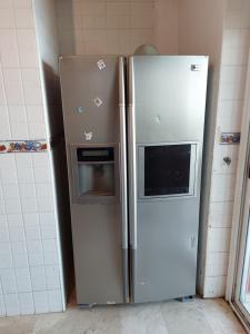 a refrigerator with a microwave in a kitchen at Appartement au bord de l'eau in Mohammedia