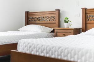 dos camas sentadas una al lado de la otra en un dormitorio en Hotel Chalet La Sofia by Majuva, en Armenia