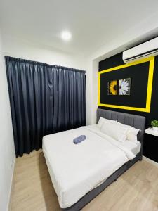 a bedroom with a bed with a black and yellow headboard at Arte Plus KL By Rainbow in Kuala Lumpur