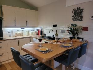 a kitchen with a wooden table with two glasses of wine at The Cabin at Forestview Farm in Greenisland