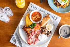 a plate of breakfast food with bacon beans and toast at The Cow & Calf by Innkeeper's Collection in Ilkley