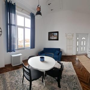 Una sala de estar con una mesa y sillas blancas. en Weisz Apartment-City Center-Free Private Parking,Wifi,Air conditioner, en Carei