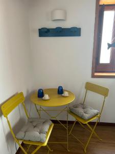 un tavolo giallo e due sedie in una stanza di Boccaporto a Polignano a Mare