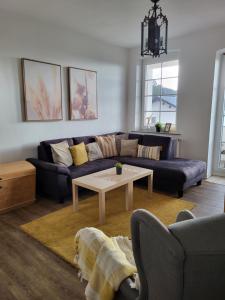 uma sala de estar com um sofá e uma mesa em TKS-HOME em Mündersbach