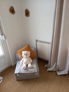 a teddy bear sitting on a chair in a room at Au bord du Vilpion in Marle-et-Behaine