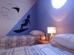 a bedroom with two beds with a mermaid on a surfboard at 1780 Alojamiento in Guaymallen