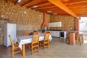 Casa São Luis في ليندويا: مطبخ مع طاولة وكراسي وجدار من الطوب