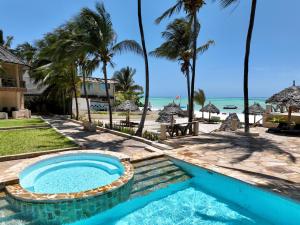 uma piscina com praia ao fundo em Zula Zanzibar em Paje