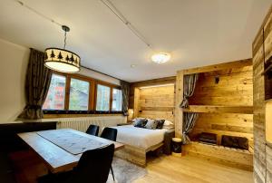 a bedroom with a bed and a table and chairs at Il Ruscello Mountain Apartment in Madesimo