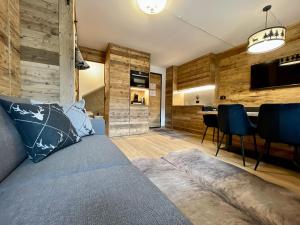 a bedroom with a couch and a dining room at Il Ruscello Mountain Apartment in Madesimo