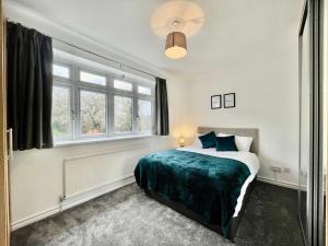 a bedroom with a bed and a large window at Modern 3 Bed Chigwell House (Free Parking) in Chigwell