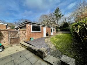 a brick house with a gate and a yard at Modern 3 Bed Chigwell House (Free Parking) in Chigwell