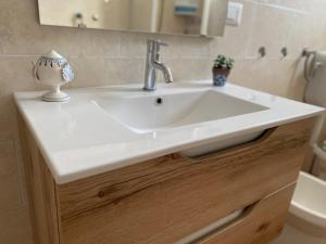a white sink in a bathroom with a toilet at Casa vacanze Madre Terra in Putignano