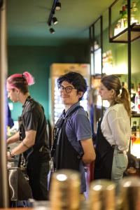 a group of three people standing in a kitchen at Black Llama Hostel in Lima