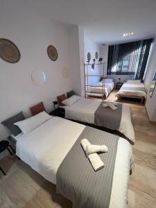 1 dormitorio con 2 camas y toallas. en Pensión Les Eres, en Puebla de Vallbona