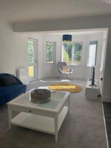 uma sala de estar com um sofá e uma mesa em Sunny Corner - lovely 2 bedroom appt em Redruth
