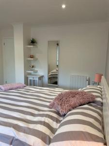um quarto com uma cama grande e uma almofada. em Sunny Corner - lovely 2 bedroom appt em Redruth