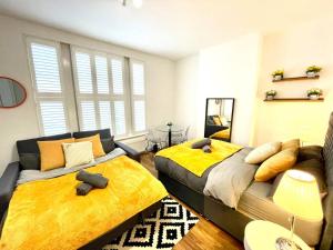 a bedroom with two beds and a couch at Cosmopolitan Stays in London