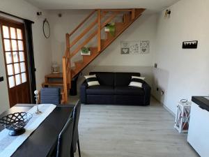 a living room with a black couch and a staircase at Maison de Denise in Lezzeno