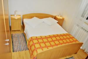 a bedroom with a bed with two night stands and two lamps at Apartments Buljevic in Vrboska