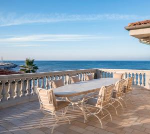 een tafel en stoelen op een balkon met uitzicht op de oceaan bij Villa Teti in San Vincenzo
