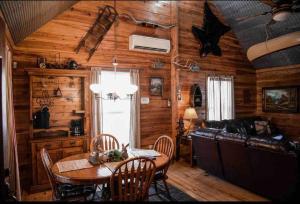 ein Esszimmer mit einem Tisch und einem Sofa in der Unterkunft Collier Cabin on Collier Creek in Norman