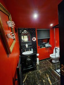 a red bathroom with a sink and a toilet at Wednesday's Family Rooms in York