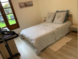 Schlafzimmer mit einem Bett mit weißer Bettwäsche und Kissen in der Unterkunft Le paradis des oiseaux in Saint-Gildas
