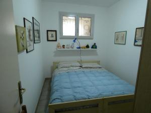 Cama pequeña en habitación con ventana en Casa Licanio, en Bibione