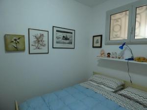 - une chambre avec un lit et des photos sur le mur dans l'établissement Casa Licanio, à Bibione